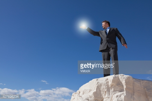 a Getty Images stock image of a man in a suit holding a glowing white light.